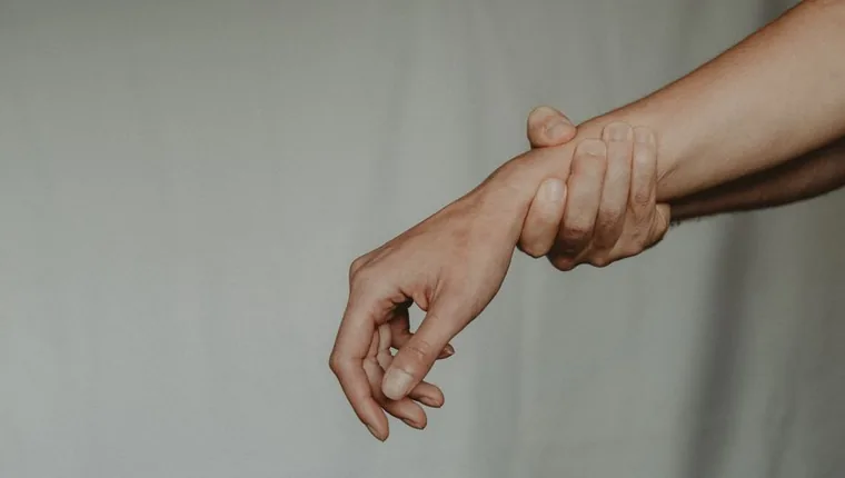 한쪽 손으로 반대편 손목을 잡아 전완을 늘리는 스트레칭 동작
